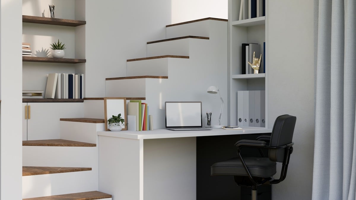 Home working space interior design in modern minimal white style with laptop on white desk against the staircase with built-in shelves and home decor