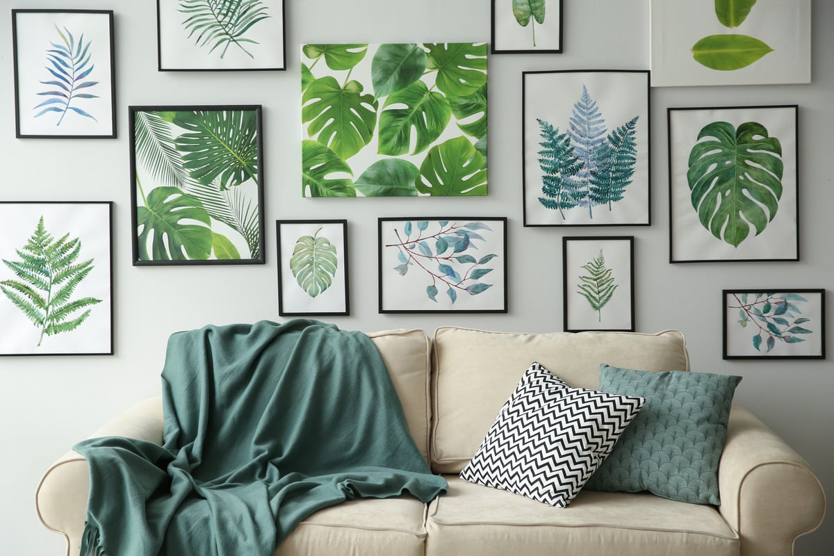 artworks of leaves on a wall above a comfortable couch in a stylish room