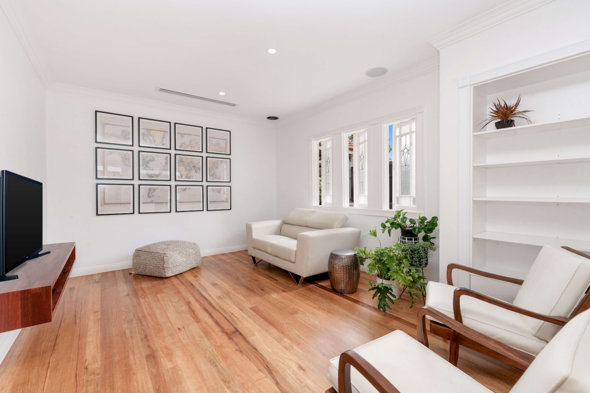 a living room filled with furniture and a flat screen tv, and a photo wall forming a map