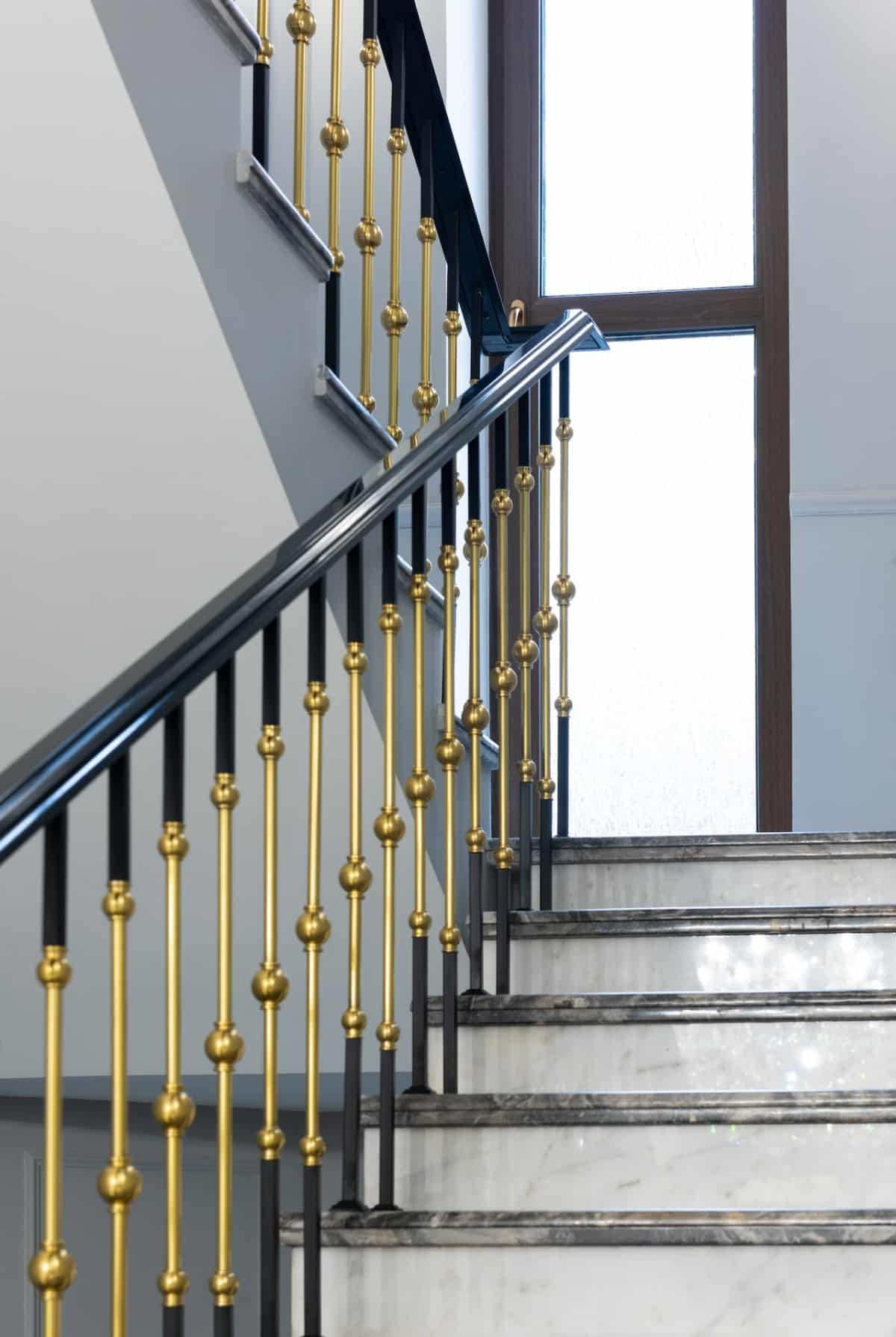 Staircase with marble steps and metal banister in house