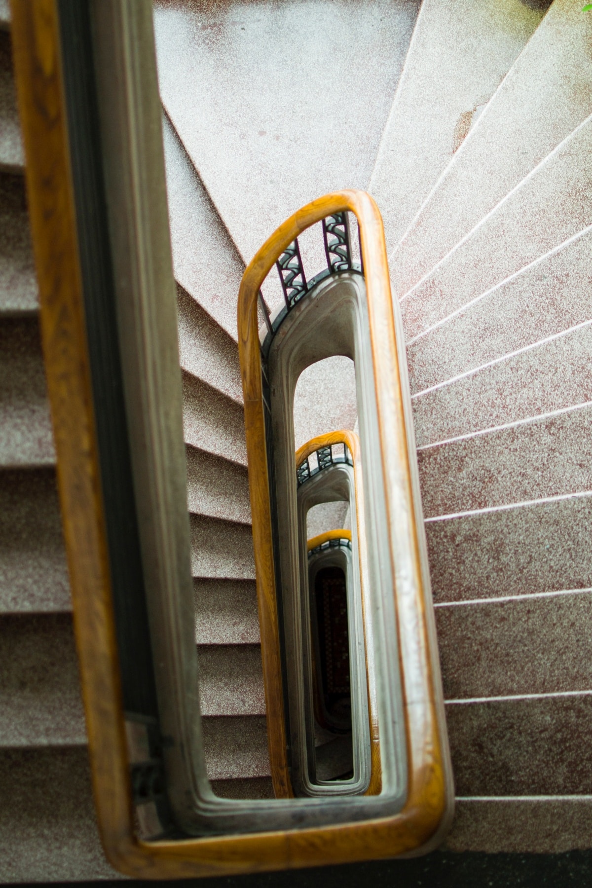 Grey stone spiral staircase with wooden hand rails