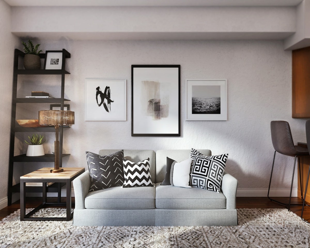 three framed pictures above couch with white and black throw pillows
