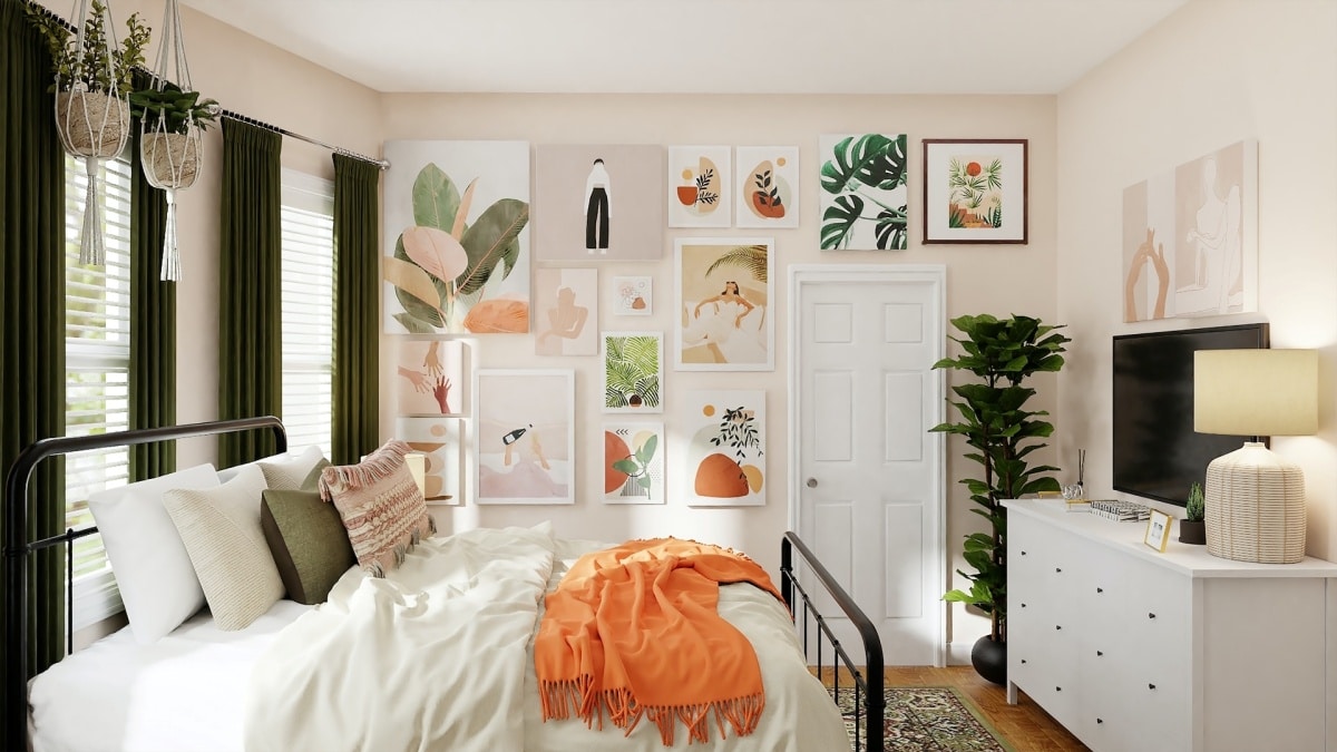 white bed with orange blanket in bedroom with photo wall