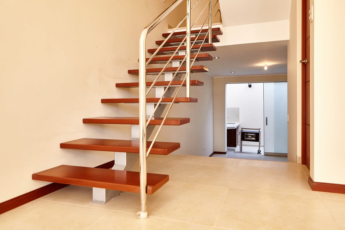 Wood floating staircase in an empty living room