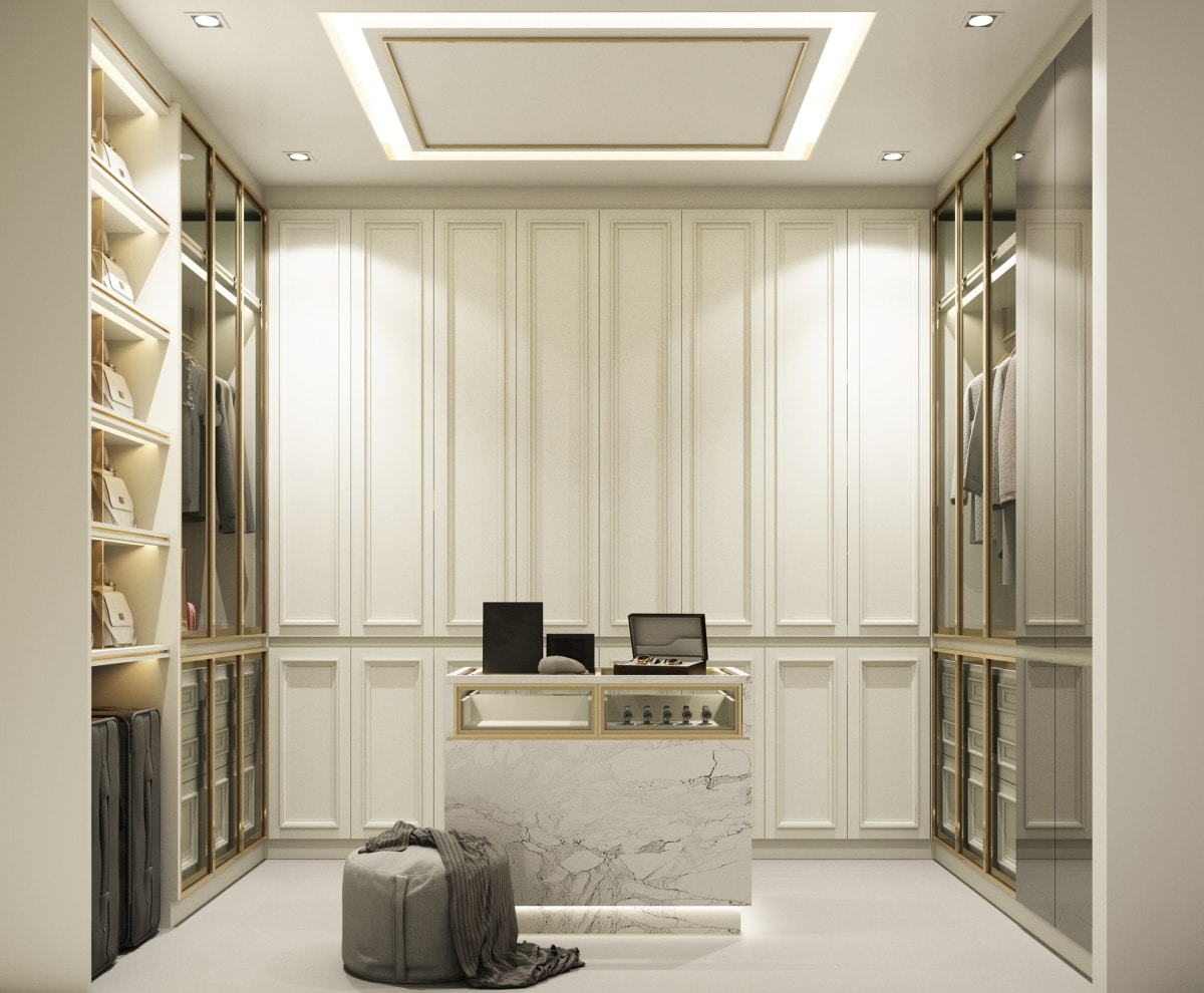 interior of a walk-in closet with white marble floor tile, marble island, and gray stool
