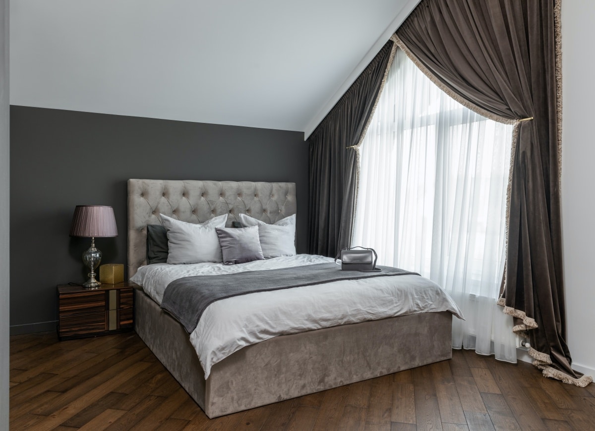 Grey bedroom interior with pillows on bed