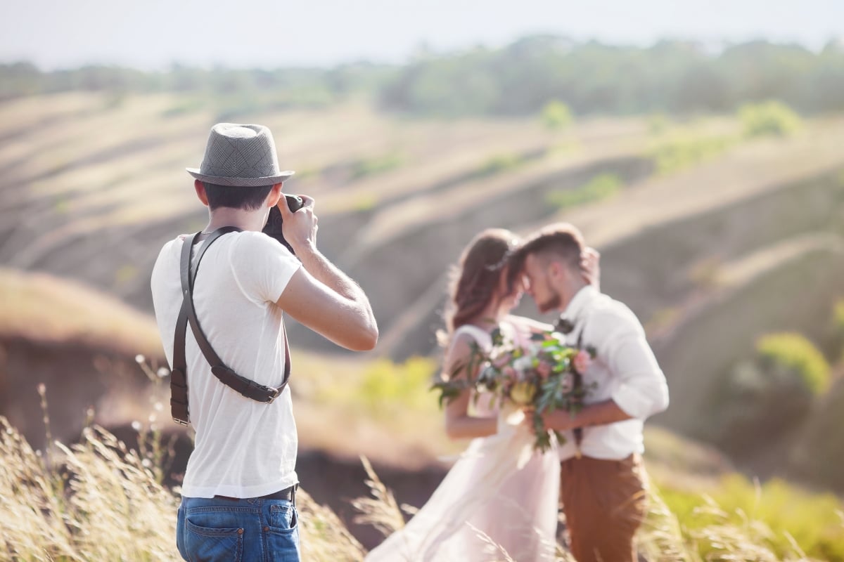 A photographer takes pictures of the bride and groom after the ceremony.