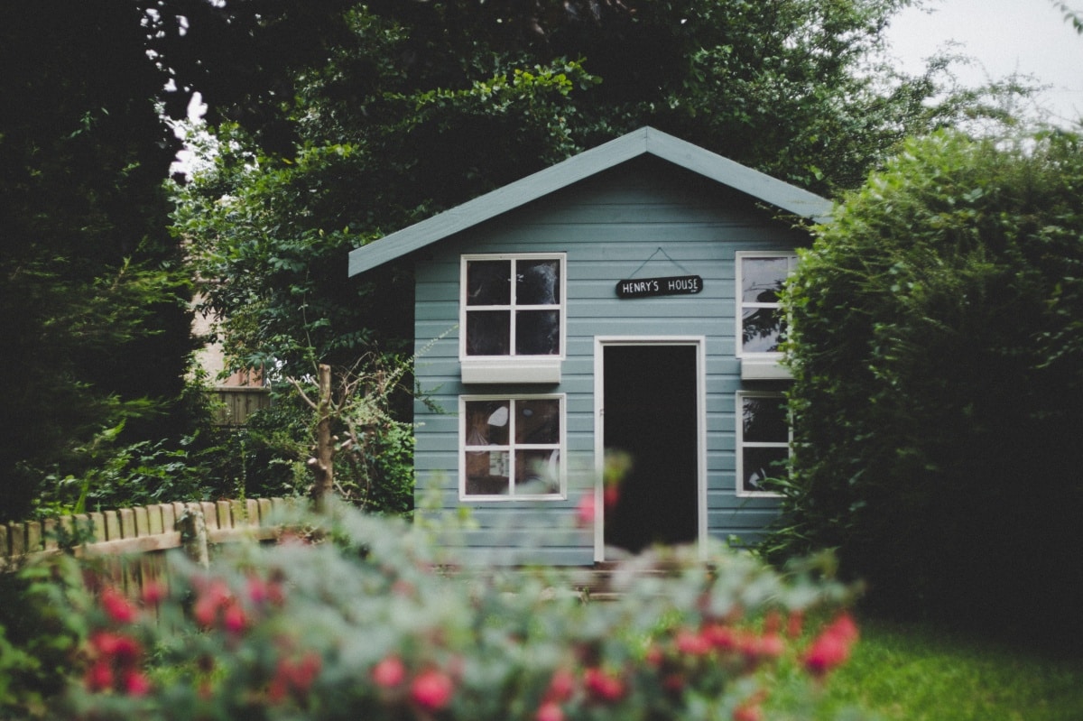 Classy blue cubby house in a garden