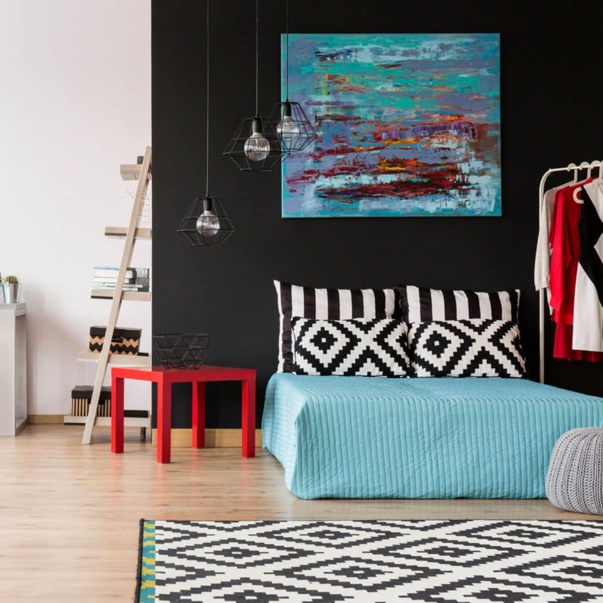 a teal bedroom with black, white, and red decor and furniture