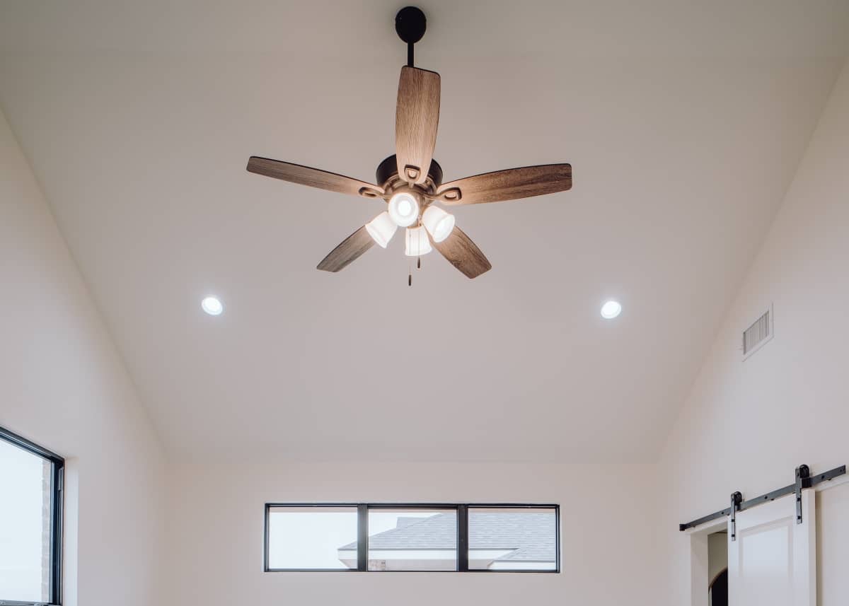 contrasting dark brown fan on white high ceiling