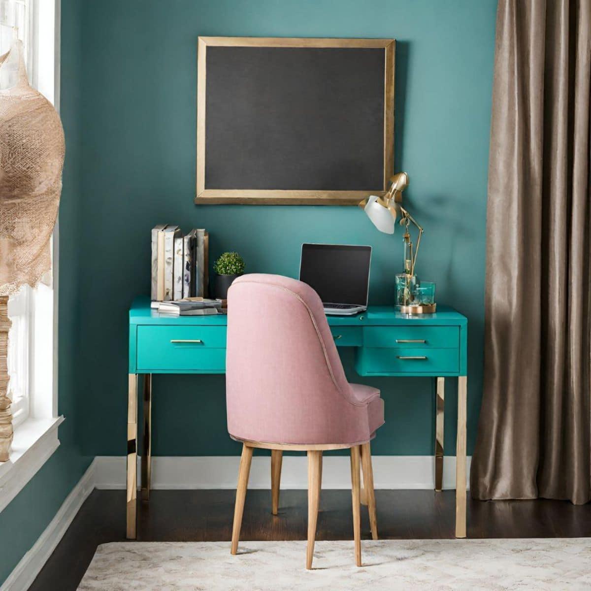 a teal desk with a laptop, books, and pink chair