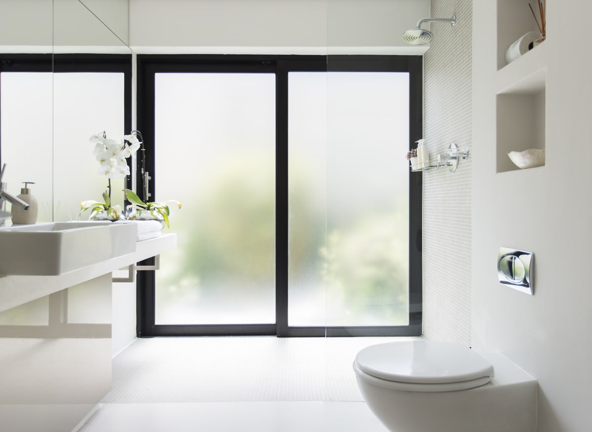 clean white bathroom with frosted sliding door