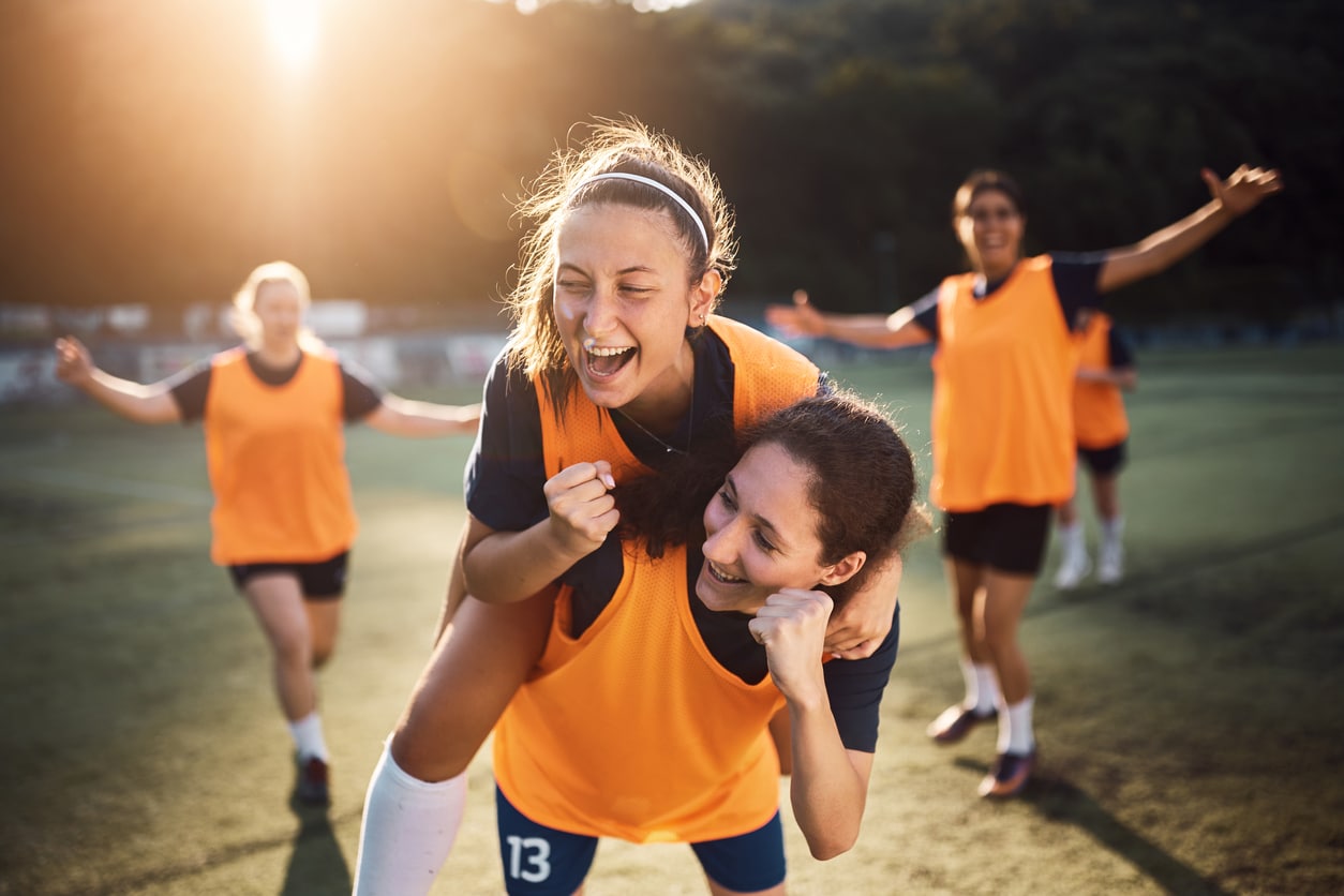 Happy female players celebrating a goal during soccer match