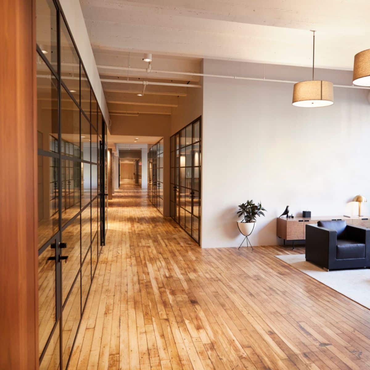 A large hallway with wooden floors and doors with mirrors