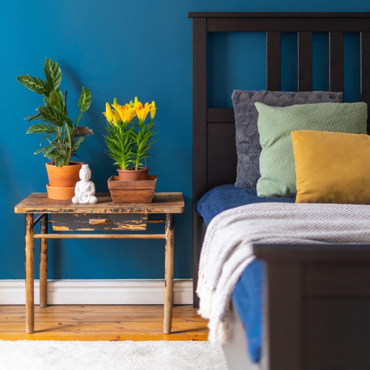 A teal bedroom with yellow flowers and pillow