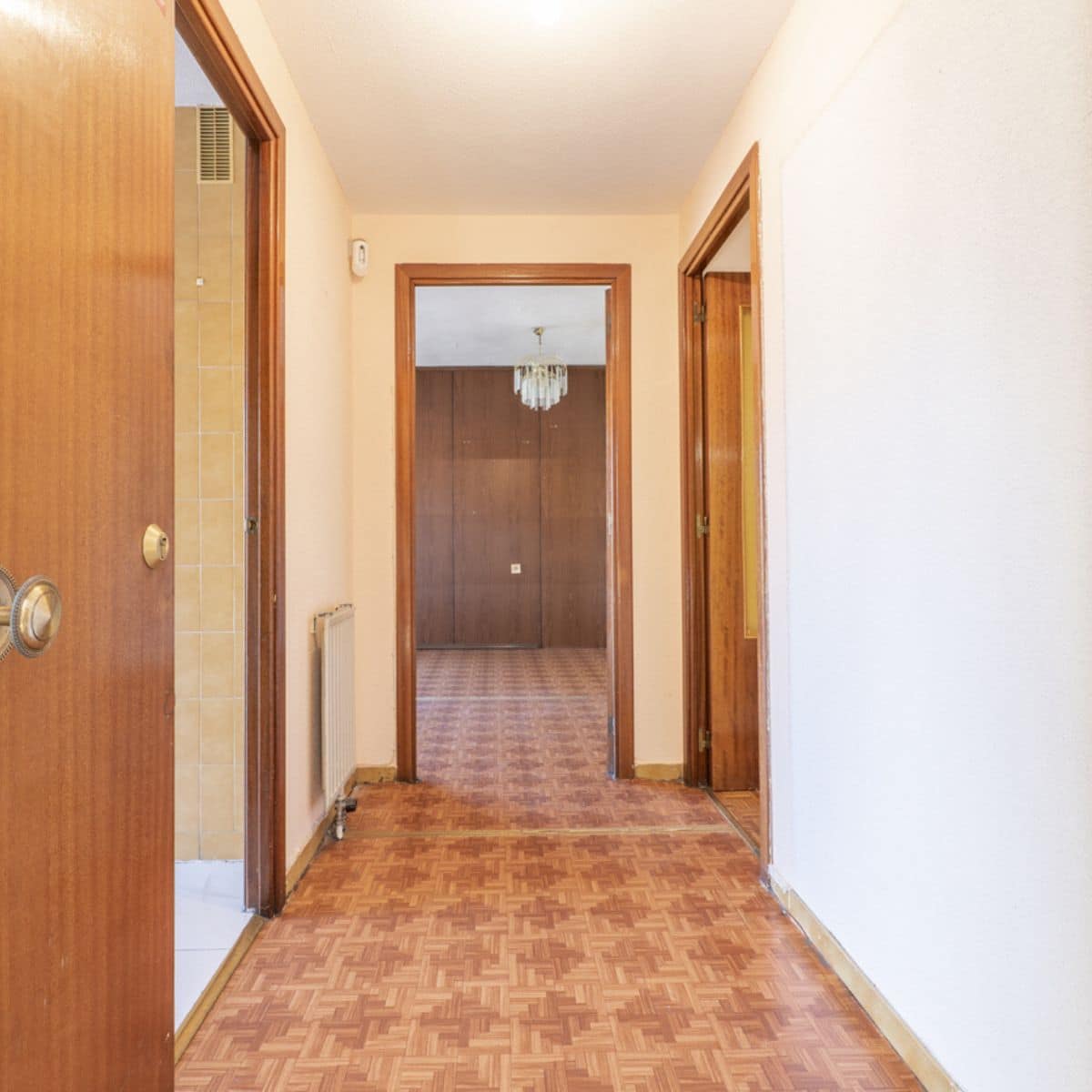 a long hallway with wooden doorways