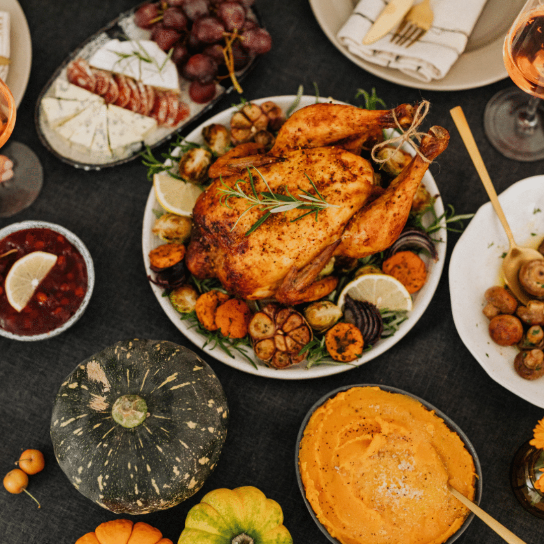 A plate of turkey and bowls of side dishes prepped for Thanksgiving dinner.