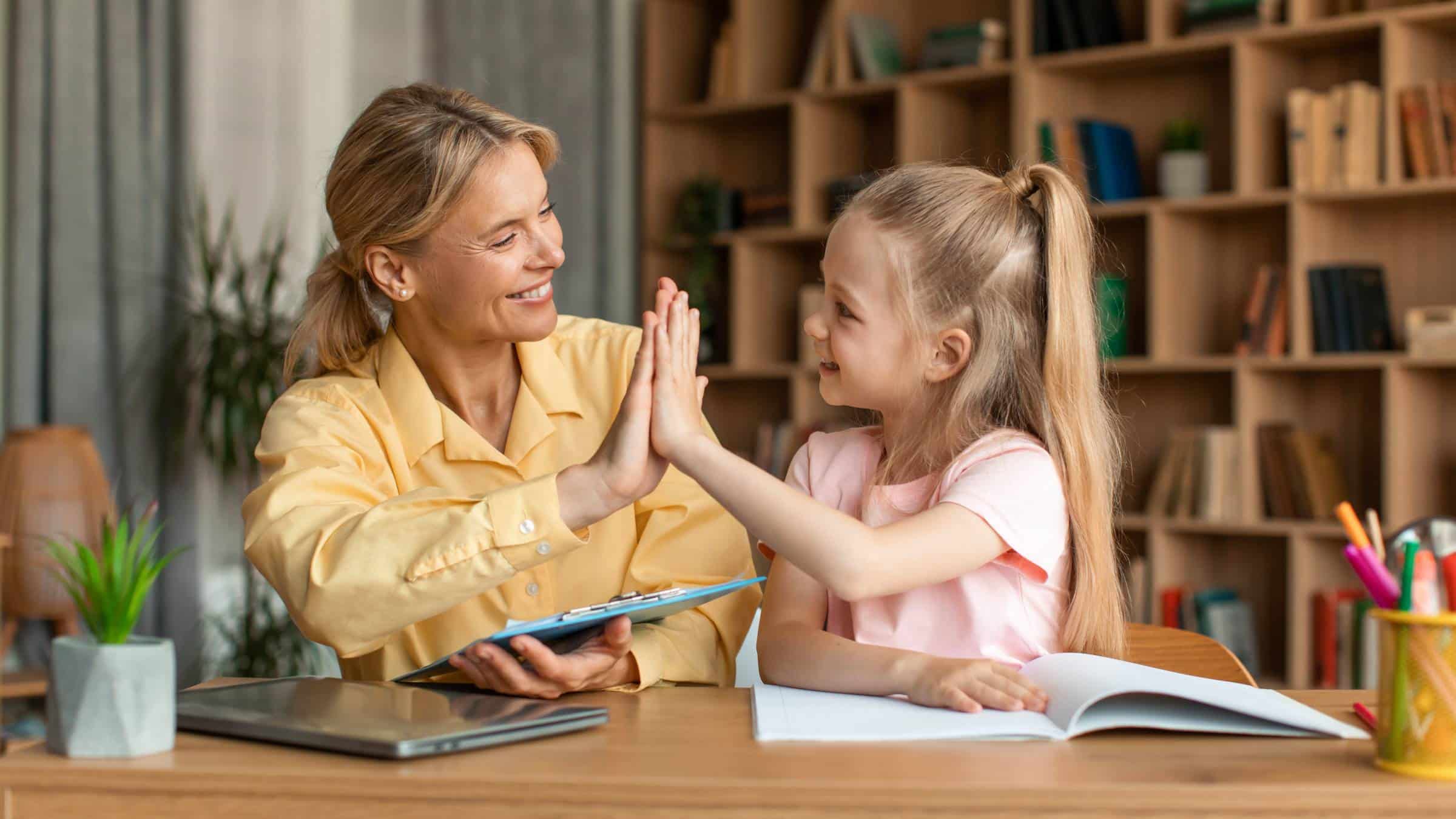 a girl high-fiving her private tutor at home