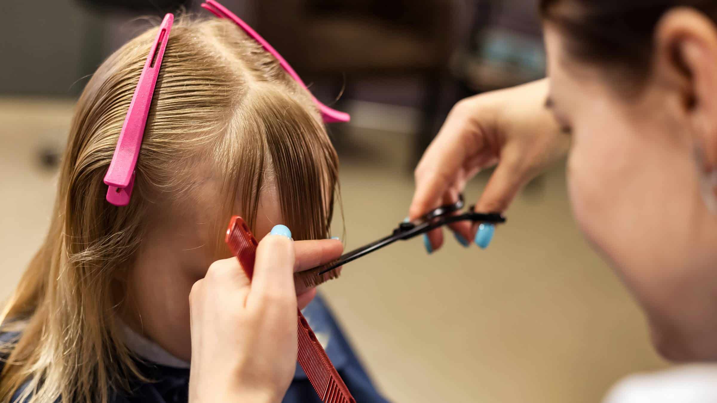 a little girl getting her hair trimmed