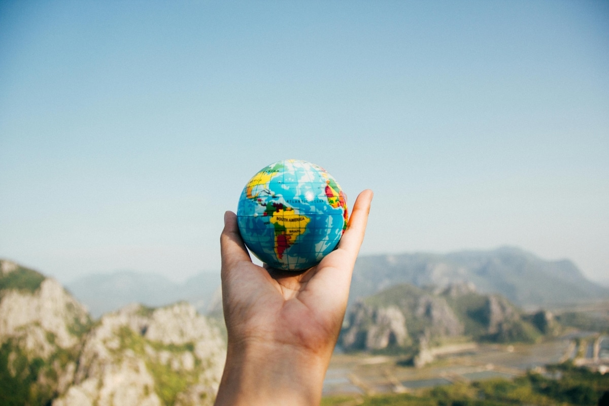 A hand holding a globe in honor of Earth Day.