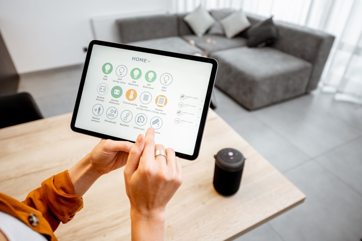 A woman controlling her home's lights and appliances with a home automation system.