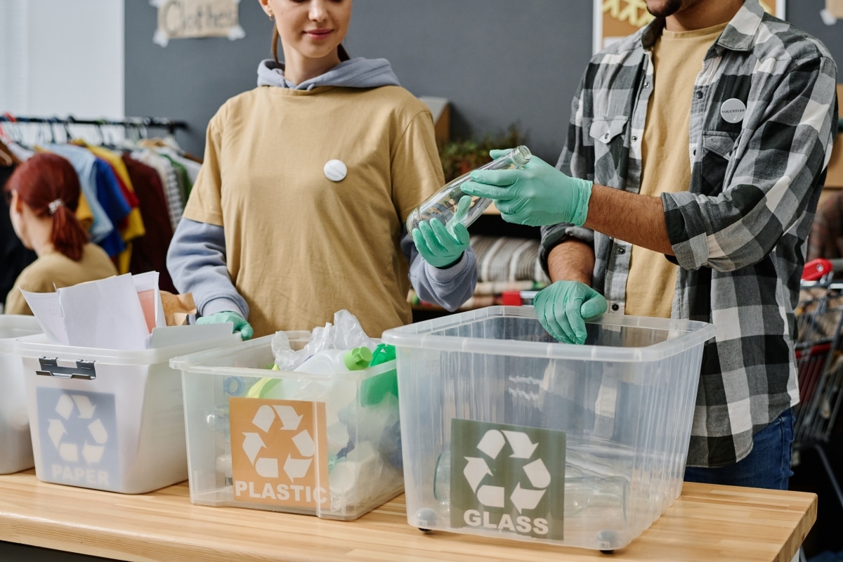 A group of people segregating waste into recycling bins.