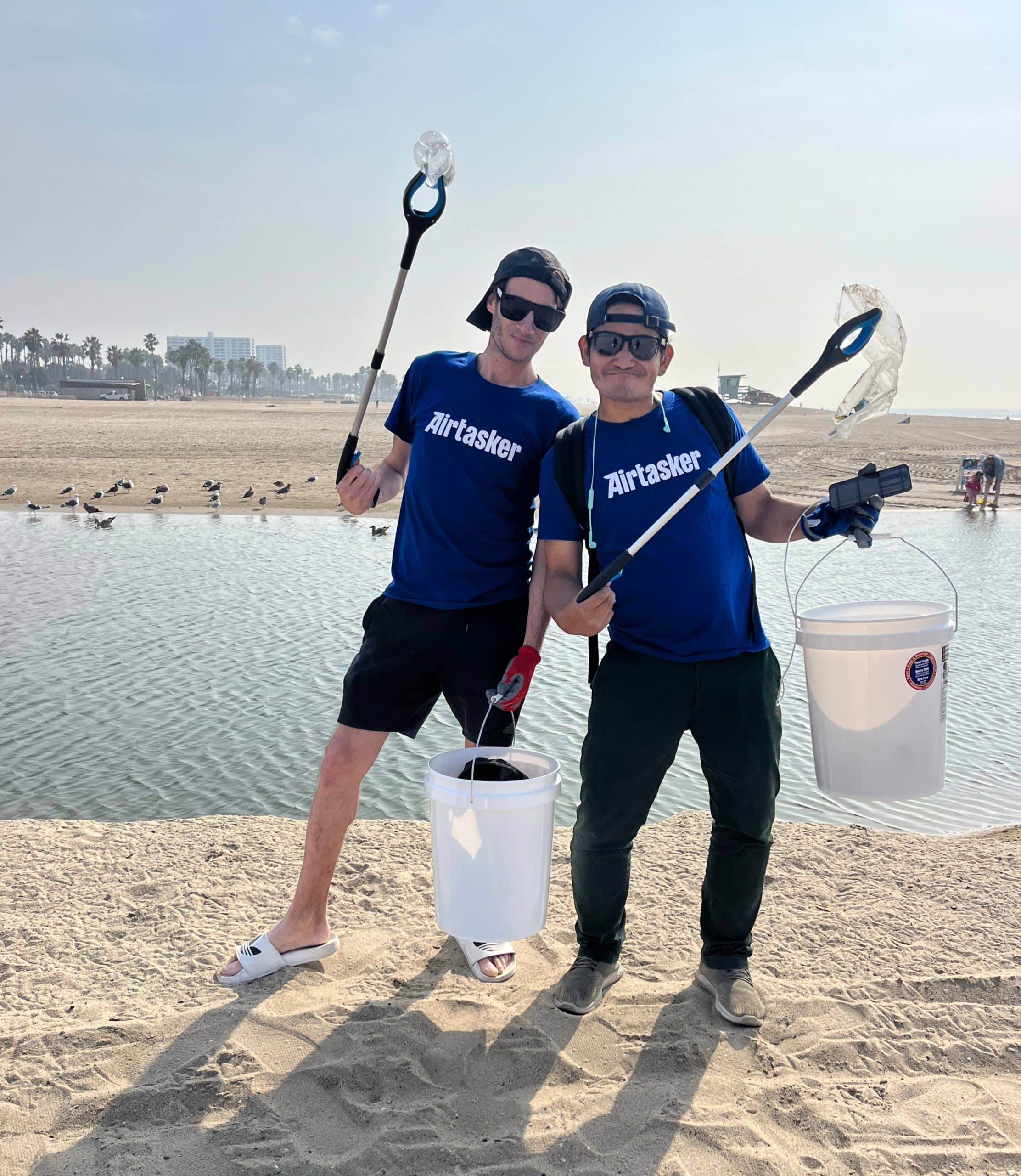 Taskers picking up trash along the beach in Los Angeles.