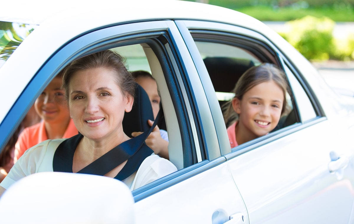 A mother driving her kids to school.