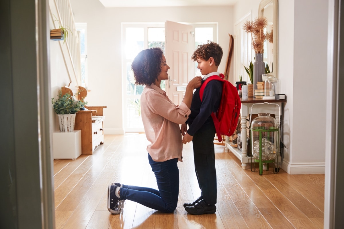 A mother prepping her son for his first day of school.