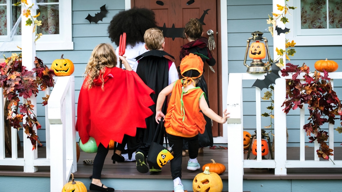Young kids in costumes trick or treating during Halloween